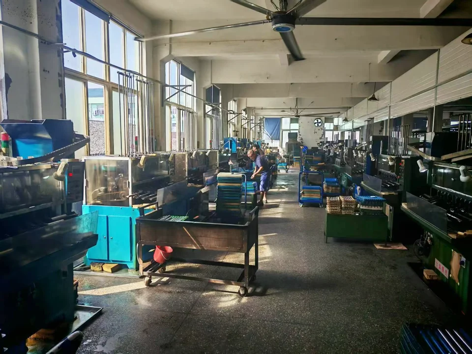 Equipment, worktables and trays on both sides of a workshop aisle at the GDQV factory
